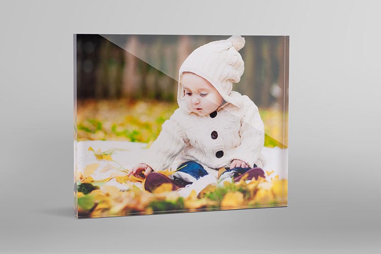 Personalised desk gift of a glass photo block of a baby in the autumn leaves